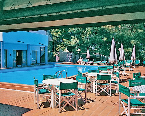 An outdoor fine dining restaurant alongside a swimming pool.
