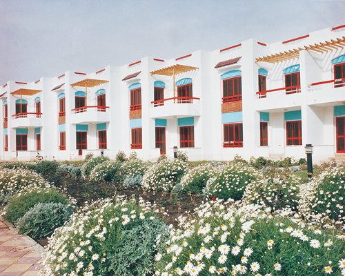 An exterior view of multi story resort units with flowering shrubs.