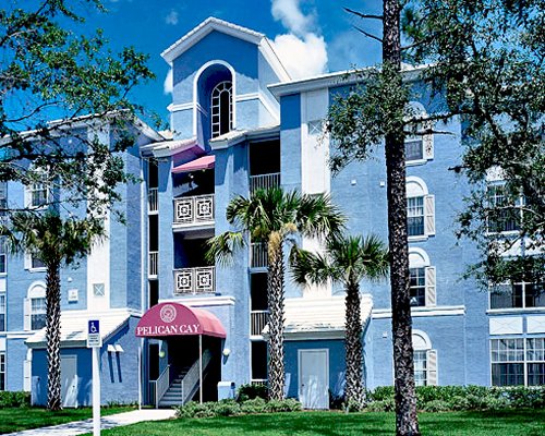 An exterior view of multi story resort unit with trees.