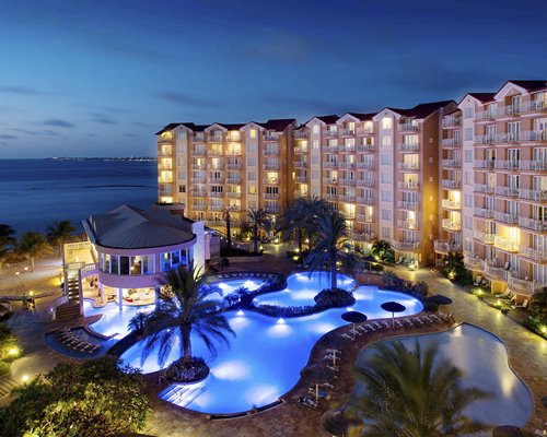 Divi Aruba Phoenix Beach Resort with an outdoor swimming pool at dusk.