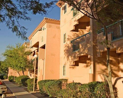 Exterior view of multiple unit balconies alongside a pathway.