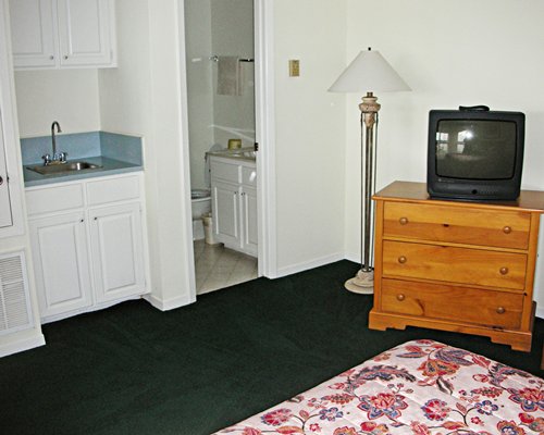 A well furnished bedroom with a king bed and television.