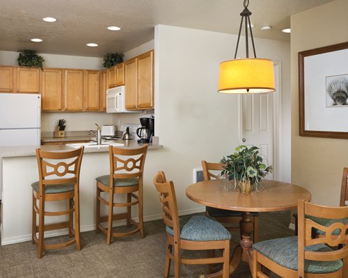 An open plan kitchen with breakfast bar and dining area.
