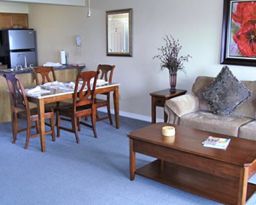 An open plan living and dining area with a pull out sofa alongside kitchen.