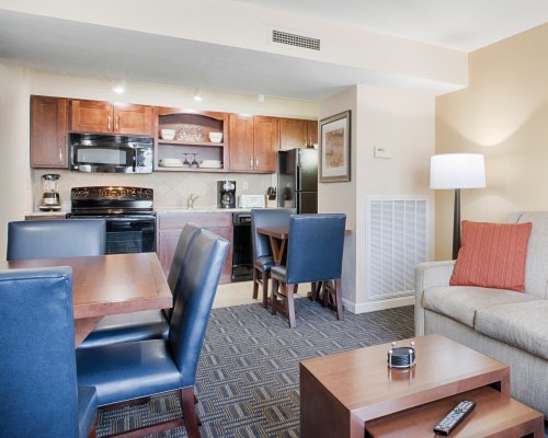 AN OPEN PLAN LIVING ROOM DINING AREA AND KITCHEN WITH BREAKFAST BAR.