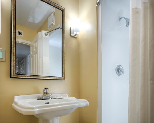 A BATHROOM WITH A SHOWER AND SINGLE SINK VANITY.