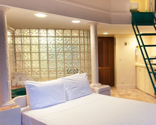 A well furnished bedroom with a staircase.