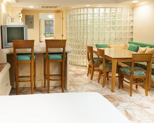 A well furnished dining room alongside a breakfast bar.
