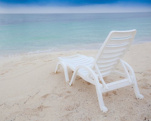 View of the beach with chaise lounge chair.