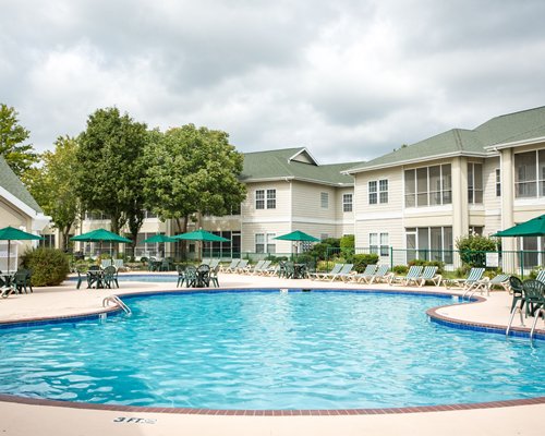 Exterior view of the resort with chaise lounge chairs alongside the swimming pool.
