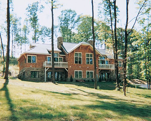 An exterior view of a unit with balconies surrounded by trees.