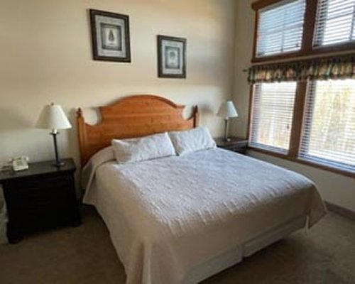 A well furnished bedroom with multiple king bed and lamp.