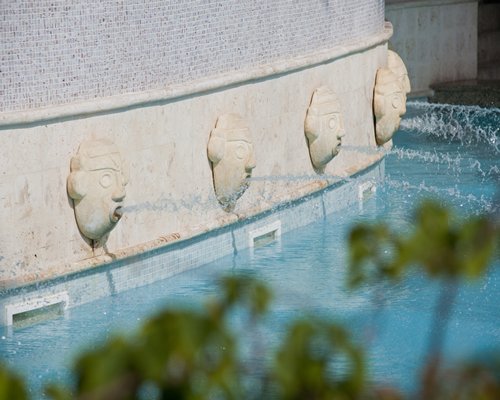 Several water features alongside a swimming pool.