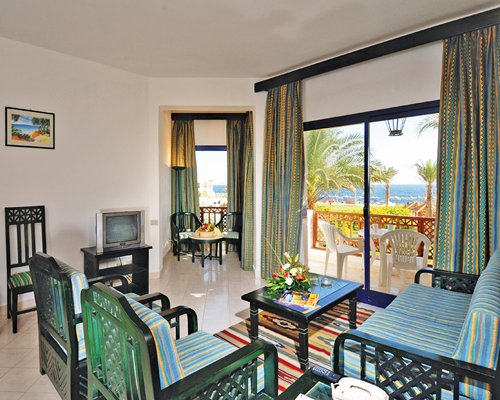A well furnished living room with a television and balcony.