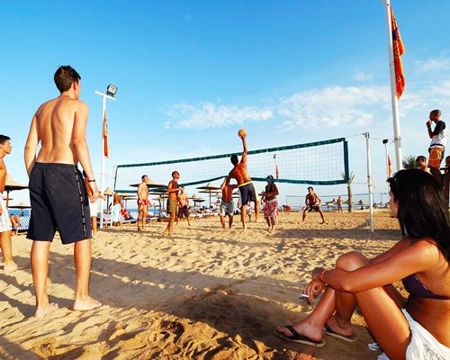 View of people playing volley ball at the beach.