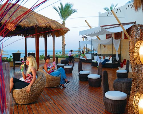 View of people having the beverage at the lounge area with beach beds.