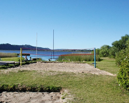 Outdoor recreation area with tennis court alongside the water.