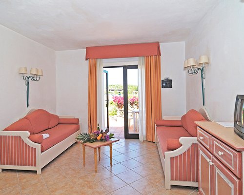 A well furnished living room with television outdoor patio and patio chairs.