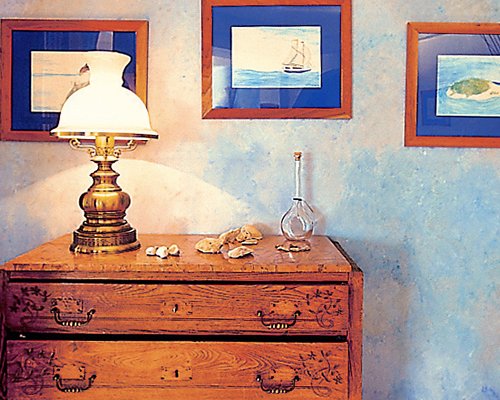 Room with lamp candle and framed photos.