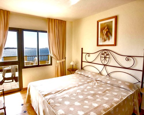 A well furnished bedroom with a balcony.