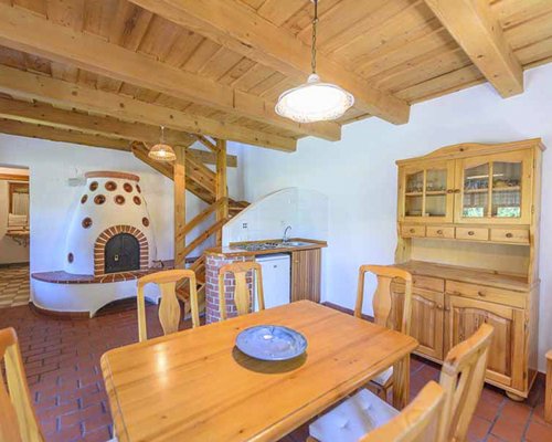 Dining area with fireplace and wooded stairway.