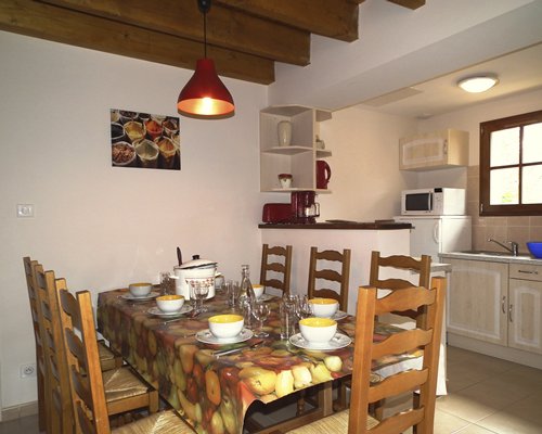 A furnished dining room and a kitchen area.
