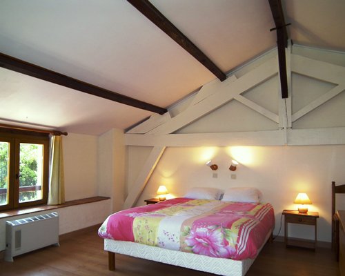 A furnished bedroom with a king bed and outdoor view.