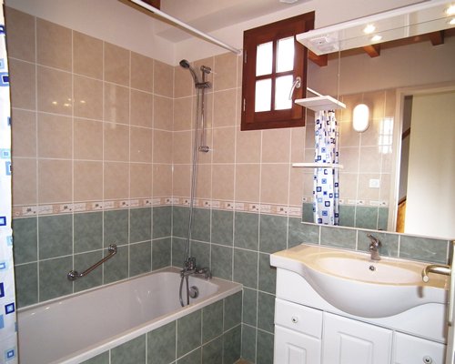 A bathroom with single sink vanity and a bathtub.