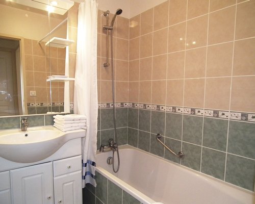 A bathroom with single sink vanity and a bathtub.