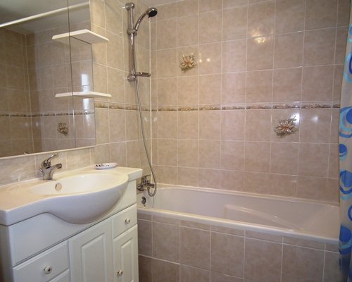 A bathroom with single sink vanity and a bathtub.