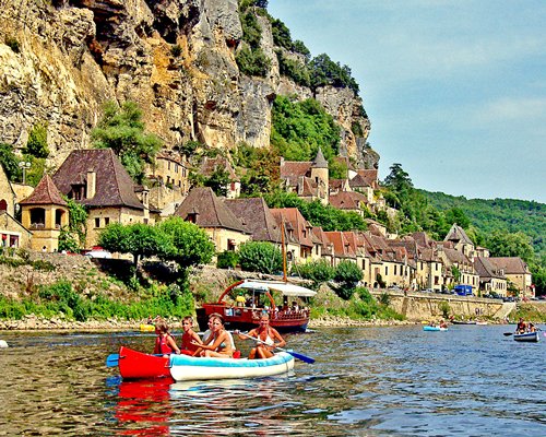 Group of people kayaking in a waterfront alongside multiple resort units.