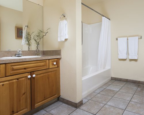 A bathroom with a bathtub shower and sink vanity.