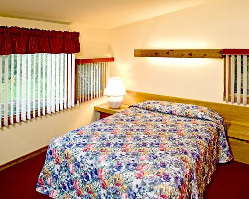 A well furnished bedroom with a queen bed and an outside view.