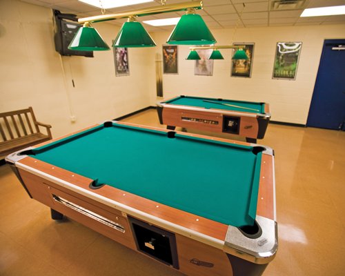 An indoor recreation room with two pool tables.