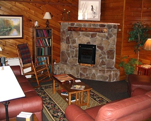 A wood paneled living room with queen pull out sofa and stone fireplace.