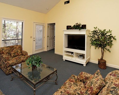 A well furnished living room with a television and an outside view.