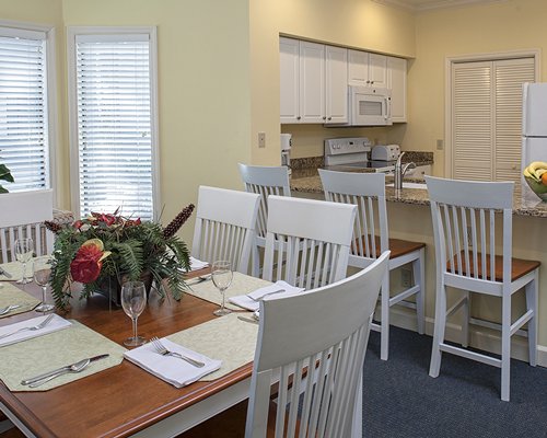 A well furnished dining area alongside kitchen with a breakfast bar.