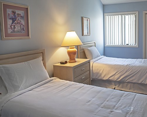 A well furnished bedroom with two twin beds and an outside view.