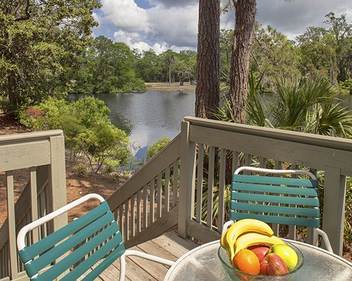 An outdoor patio with the waterfront surrounded by wooded area.