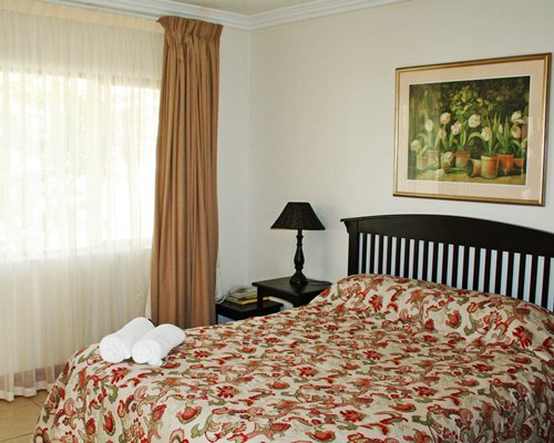A well furnished bedroom with king bed and outside view.