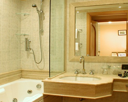 A bathroom with a shower bathtub and single sink vanity.