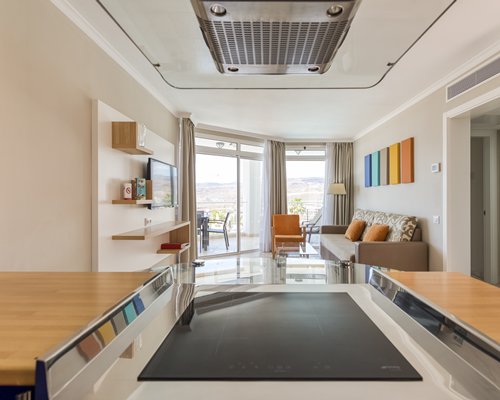 An open plan living and kitchen with breakfast bar and a television.