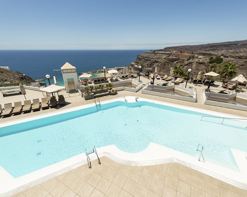 View of multiple unit balconies with stairway and outdoor swimming pool.