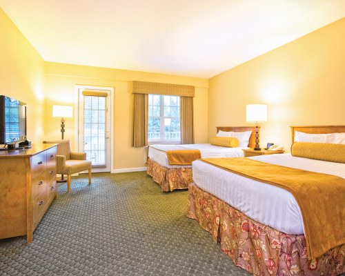 A WELL FURNISHED BEDROOM WITH TWO BEDS TELEVISION AND AN OUTSIDE VIEW.