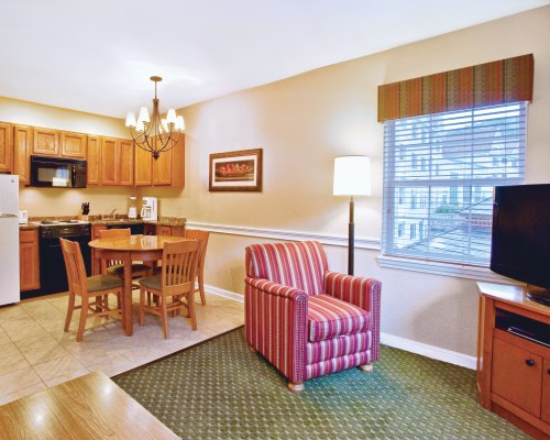 FURNISHED LIVING ROOM WITH A TELEVISION DINING AREA OPEN PLAN KITCHEN AND OUTSIDE VIEW.