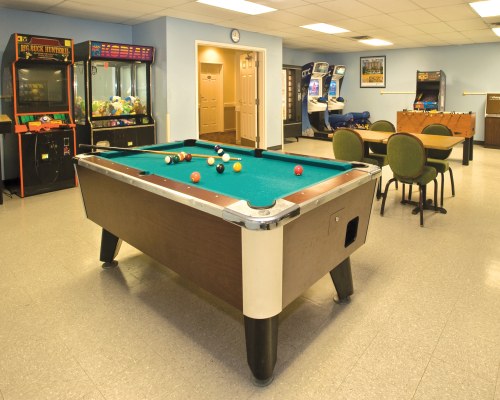 INDOOR RECREATION ROOM WITH ARCADE GAMES AND POOL TABLE.