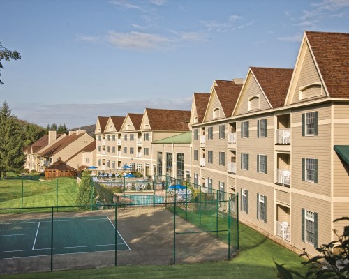 SCENIC VIEW OF AN OUTDOOR TENNIS COURT ALONGSIDE THE RESORT UNIT.