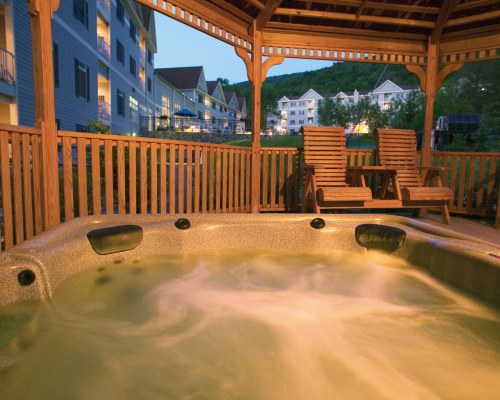 AN INDOOR HOT TUB WITH CHAISE LOUNGE CHAIRS.