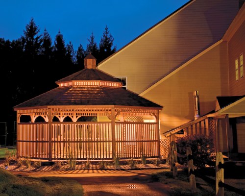 AN EXTERIOR VIEW OF A HOT TUB ALONGSIDE RESORT AT NIGHT.