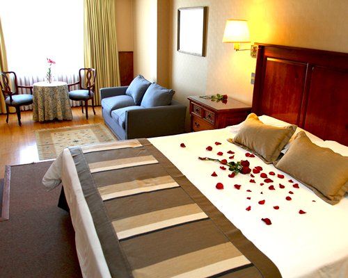 A well furnished bedroom with a king bed and dining area.